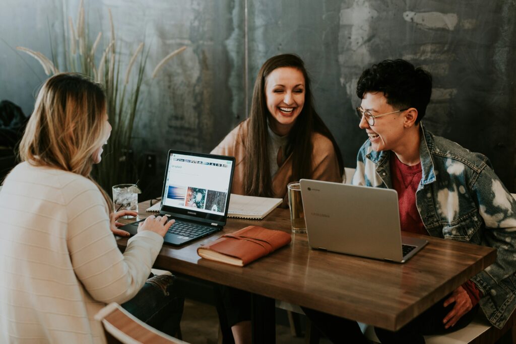 Group of women around a table with computers discussing